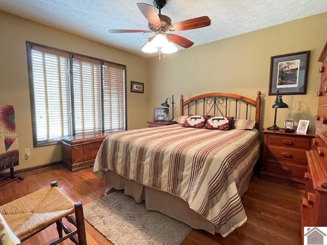 bedroom featuring baseboards, a textured ceiling, ceiling fan, and wood finished floors