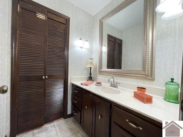 bathroom with vanity, tile patterned flooring, and wallpapered walls