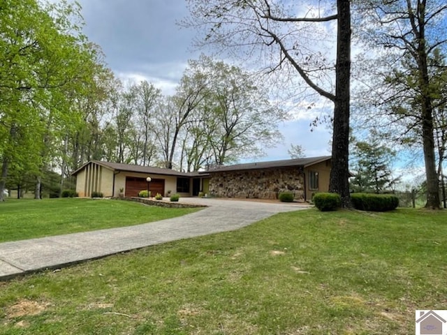 mid-century home featuring a garage, stone siding, driveway, and a front yard