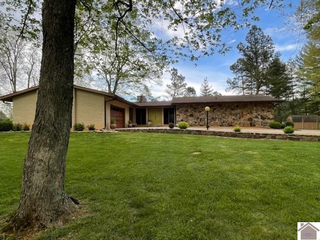 view of front of home with a front lawn, stone siding, and a garage