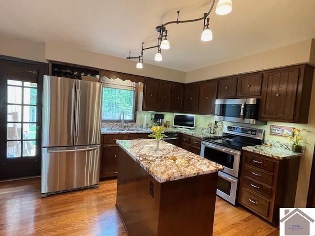 kitchen featuring appliances with stainless steel finishes, plenty of natural light, and dark brown cabinets