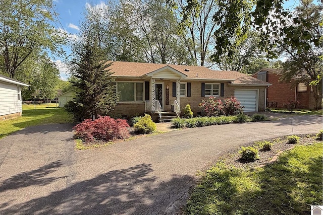 608 E 12th St, Benton, KY 42025 - view of front of house with brick siding, a garage, a front lawn, and aphalt driveway