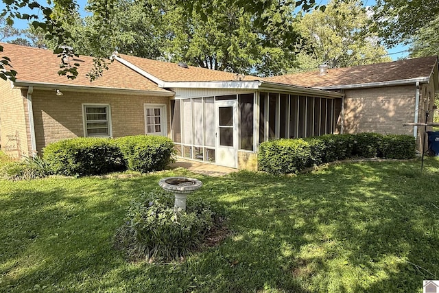 608 E 12th St, Benton, KY 42025 - back of house featuring a yard, brick siding, a fire pit, and a sunroom