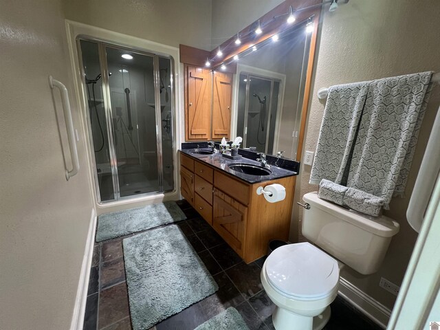 full bath featuring double vanity, toilet, a sink, and a stall shower