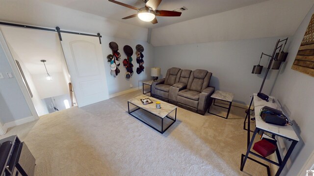 carpeted living area featuring visible vents, baseboards, ceiling fan, a barn door, and vaulted ceiling