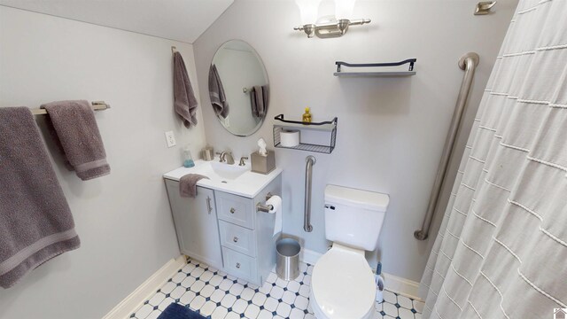 bathroom with curtained shower, baseboards, tile patterned floors, vanity, and toilet