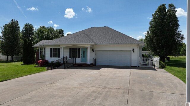 ranch-style house featuring a garage, a front lawn, fence, and driveway