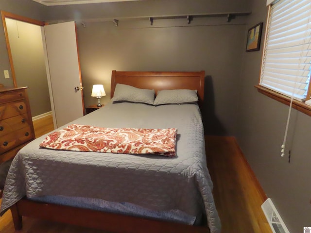 bedroom with wood finished floors and visible vents