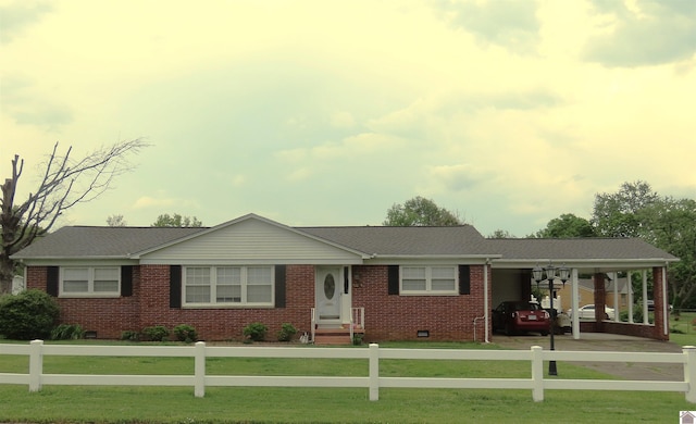 ranch-style house featuring a carport, a fenced front yard, a front yard, and brick siding