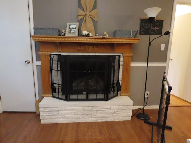 details featuring a fireplace with raised hearth and wood finished floors
