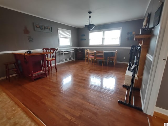dining room with crown molding, baseboards, an inviting chandelier, and wood finished floors