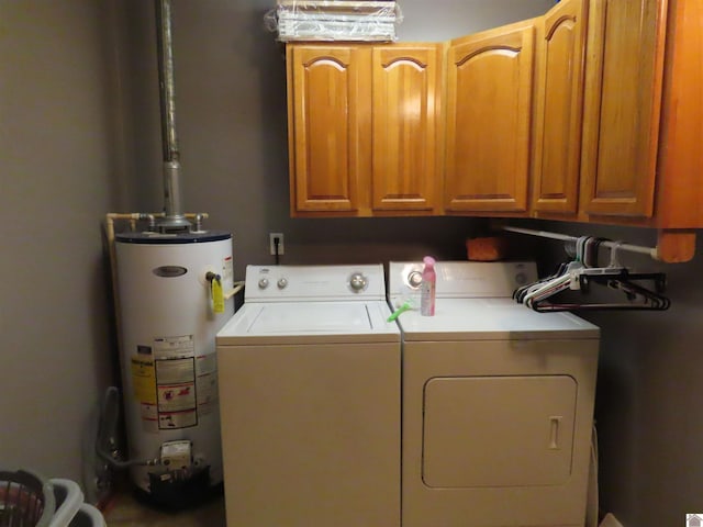 clothes washing area featuring cabinet space, washing machine and dryer, and water heater