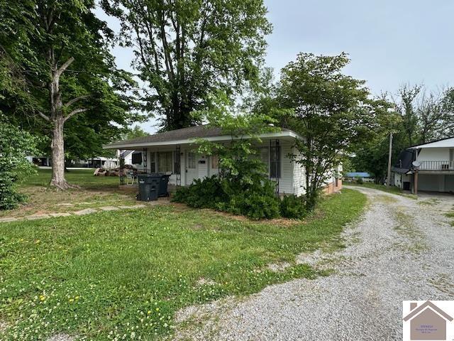 view of front of house featuring a front lawn and gravel driveway