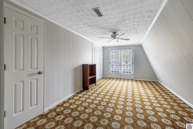 interior space with visible vents, a ceiling fan, baseboards, and a textured ceiling