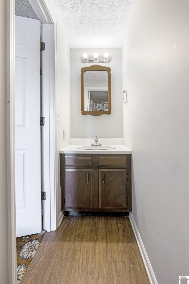 bathroom with a textured ceiling, wood finished floors, and vanity