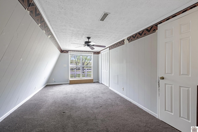 interior space with baseboards, ceiling fan, a textured ceiling, and visible vents