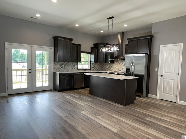 1360 Eagle Ln, Mayfield, KY 42066 - kitchen featuring appliances with stainless steel finishes, light countertops, wood finished floors, tasteful backsplash, and a kitchen island