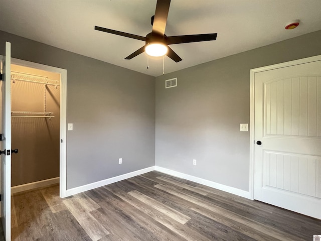 1360 Eagle Ln, Mayfield, KY 42066 - unfurnished bedroom with visible vents, a closet, baseboards, a walk in closet, and dark wood-style floors