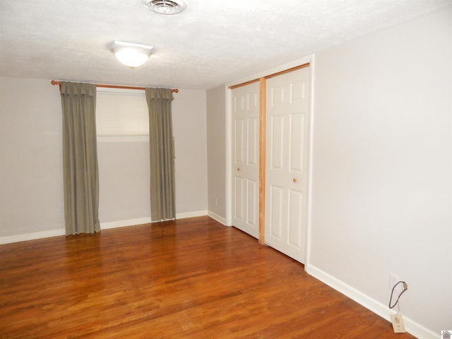 2286 Murray Hwy, Benton, KY 42025 - unfurnished bedroom with baseboards, visible vents, wood finished floors, and a closet