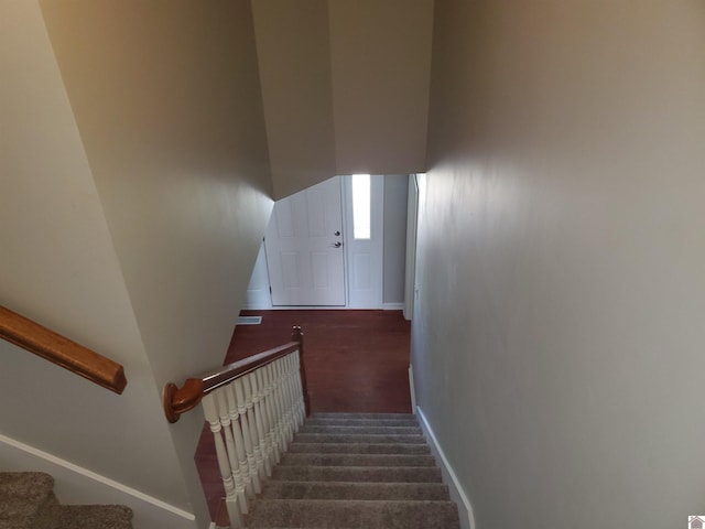 stairway featuring baseboards and carpet