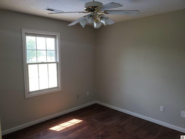 unfurnished room with dark wood-style floors, baseboards, a ceiling fan, and a textured ceiling
