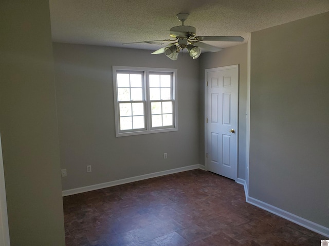 empty room with a ceiling fan, baseboards, and a textured ceiling