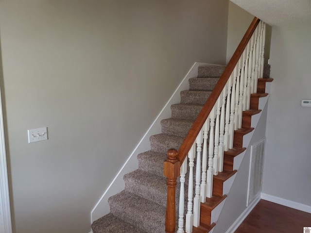 stairway with wood finished floors and baseboards