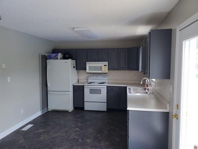 kitchen featuring white appliances, a sink, light countertops, tasteful backsplash, and baseboards
