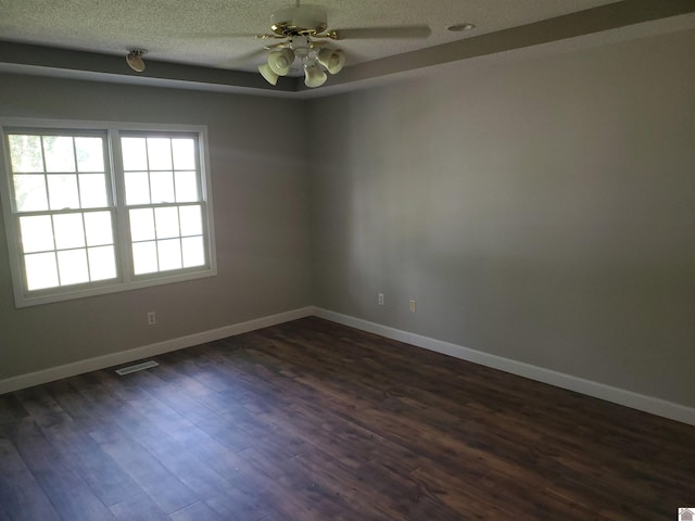 empty room featuring a textured ceiling, baseboards, ceiling fan, and dark wood-type flooring