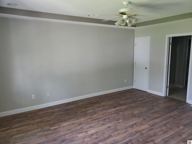 spare room with dark wood finished floors, baseboards, and ceiling fan