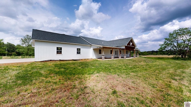 back of house with a yard and a patio