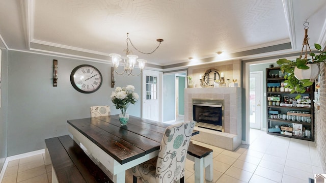 486 Mermie, Hardin, KY 42048 - dining room with a tiled fireplace, baseboards, a chandelier, ornamental molding, and light tile patterned flooring