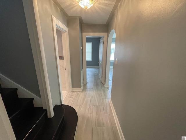 429 S 2nd St, Mayfield, KY 42066 - hallway featuring stairway, a textured ceiling, arched walkways, and baseboards
