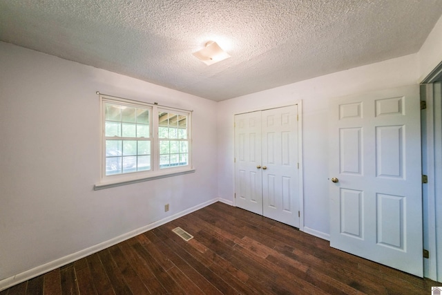 110 Clark Ln, Paducah, KY 42003 - unfurnished bedroom with a closet, a textured ceiling, visible vents, dark wood-style flooring, and baseboards