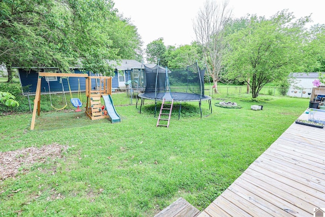 view of yard featuring a fenced backyard, a trampoline, a wooden deck, and a playground