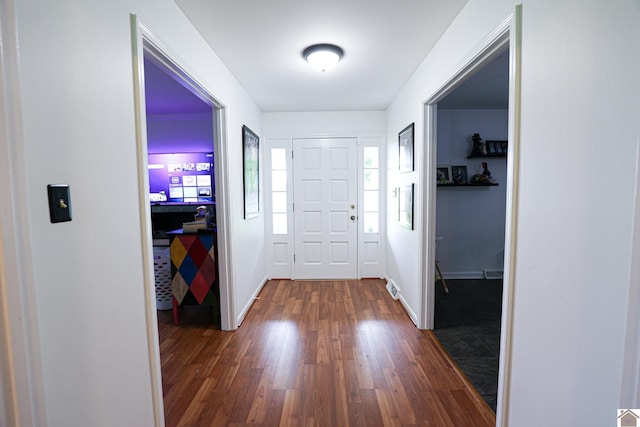 foyer with dark wood-style flooring and baseboards