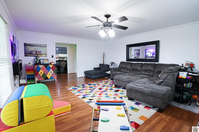 living area with wood finished floors, a ceiling fan, and ornamental molding