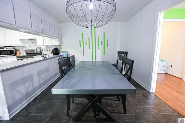 dining space with a chandelier and baseboards