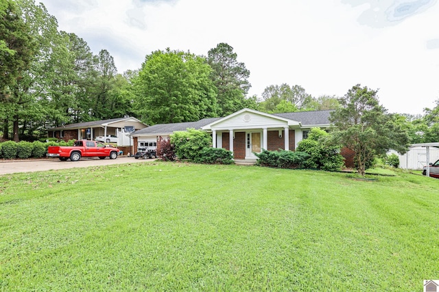 view of front of house featuring a front lawn, driveway, brick siding, and a garage