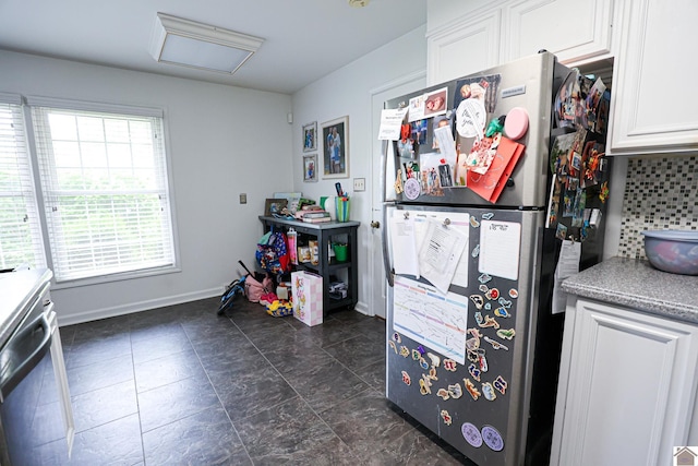 kitchen with freestanding refrigerator, baseboards, white cabinetry, backsplash, and light countertops