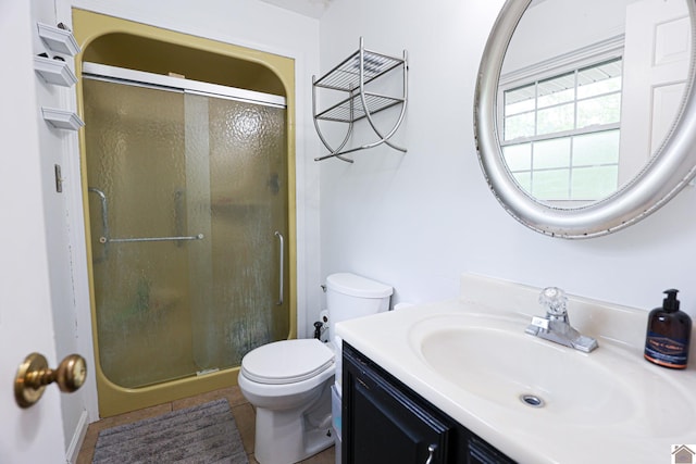 bathroom featuring tile patterned floors, vanity, toilet, and a stall shower