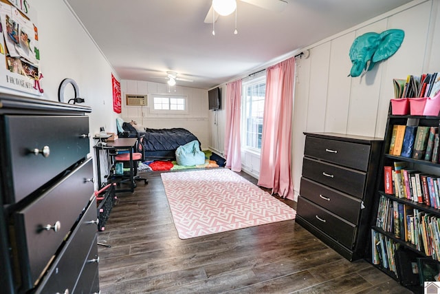 bedroom with wood finished floors, a ceiling fan, and a wall mounted AC