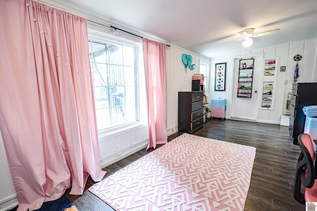 bedroom featuring ceiling fan, dark wood-type flooring, and multiple windows
