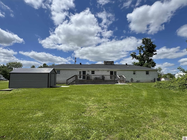 back of house featuring a yard, an outbuilding, a shed, and a wooden deck