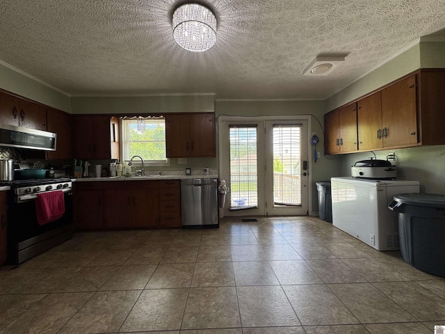 kitchen with a sink, stainless steel appliances, crown molding, an inviting chandelier, and light countertops