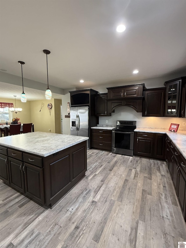 1040 Lone Valley Rd, Calvert City, KY 42029 - kitchen with stainless steel appliances, light wood finished floors, glass insert cabinets, pendant lighting, and recessed lighting