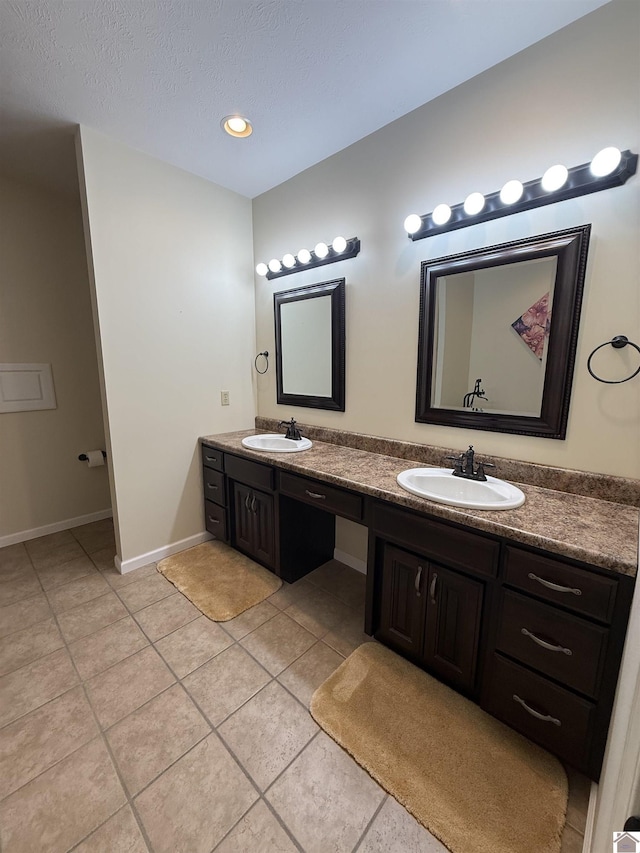 1040 Lone Valley Rd, Calvert City, KY 42029 - full bathroom with tile patterned floors, double vanity, baseboards, and a textured ceiling