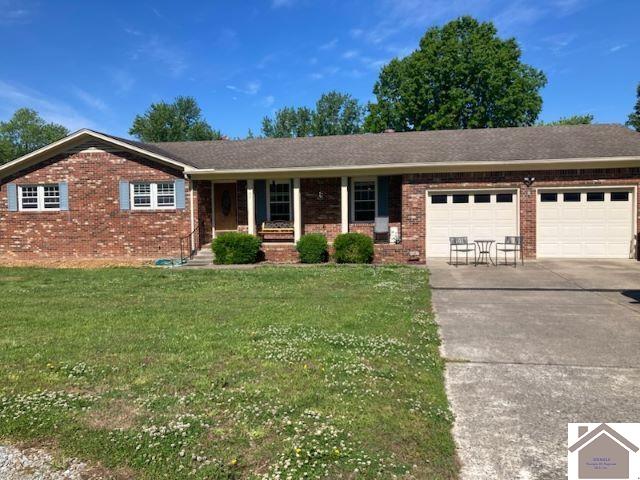 107 Monroe, Fancy Farm, KY 42039 - ranch-style house featuring a garage, brick siding, concrete driveway, a front yard, and a porch