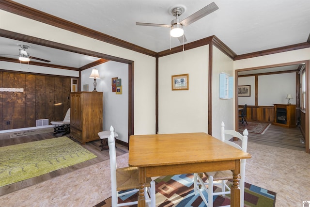 dining room featuring a ceiling fan, crown molding, and wood finished floors