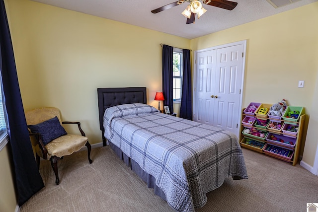 carpeted bedroom with a closet, baseboards, and ceiling fan
